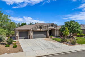Ranch-style house with a garage, stucco siding, stone siding, concrete driveway, and a tiled roof