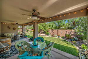 Fenced backyard with an outdoor living space, a ceiling fan, a patio area, and outdoor dining area