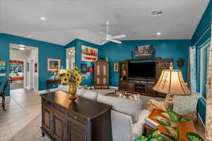 Living area featuring lofted ceiling, ceiling fan, recessed lighting, and light tile patterned flooring