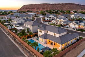 Aerial view at dusk of a residential view, view of pool area, and a mountain view