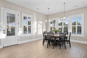 Dining space featuring a chandelier, light wood-style floors, and plenty of natural light