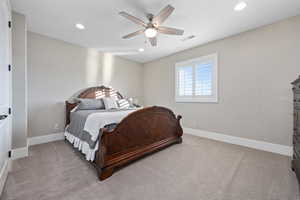 Carpeted bedroom featuring recessed lighting and a ceiling fan