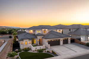View of front facade featuring an attached garage, concrete driveway, stone siding, stucco siding, and a tile roof