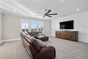 Living room with light colored carpet, crown molding, a ceiling fan, and recessed lighting