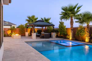 View of pool with an outdoor fire pit, a patio area, a fenced backyard, and a pool with connected hot tub