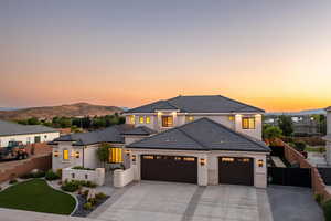 View of front facade featuring a garage, driveway, a mountain view, stucco siding, and a tile roof