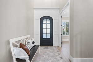 Entryway featuring arched walkways and light wood-type flooring