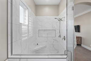 Bathroom with a shower stall and baseboards