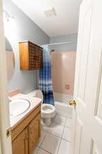 Full bathroom with vanity, tile patterned floors, and shower / tub combo with curtain