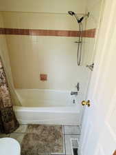 Full bathroom with shower / bathtub combination with curtain and tile patterned floors