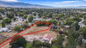 Aerial perspective of suburban area with a mountain backdrop and property parcel outlined