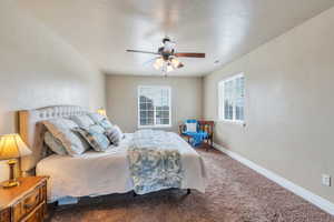 Carpeted bedroom with baseboards and a ceiling fan
