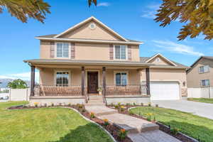 Traditional-style home featuring stucco siding, a porch, concrete driveway, and an attached garage