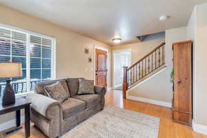 Living area featuring light wood-style floors and stairway