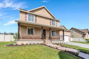 View of front of house featuring a porch, stucco siding, driveway, and a garage