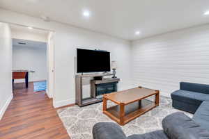 Living area featuring wood finished floors, recessed lighting, and a glass covered fireplace