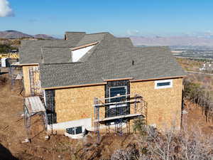 View of side of home with a shingled roof and a mountain view