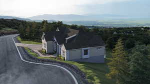 Aerial view of property and surrounding area featuring mountains and a forest