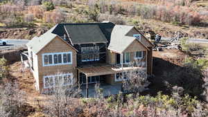 Rear view of property featuring roof with shingles