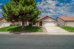Mediterranean / spanish home featuring a garage, a front lawn, driveway, a tile roof, and stucco siding