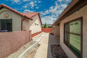 View of side of property with stucco siding, a tiled roof, and a patio area