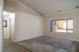Unfurnished room featuring vaulted ceiling, baseboards, and carpet flooring