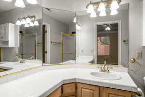 Full bathroom with a shower stall, vanity, and a ceiling fan