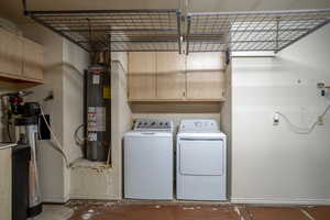 Laundry room with water heater, washer and dryer, and cabinet space