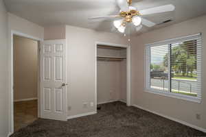 Unfurnished bedroom featuring carpet flooring, a closet, baseboards, and ceiling fan
