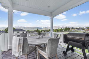 Wooden deck with a mountain view, grilling area, and outdoor dining space