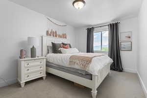 Bedroom featuring light carpet and baseboards