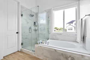 Full bath with a shower stall, a garden tub, and wood tiled floors