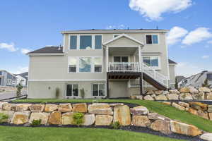 Rear view of house featuring stairway, a yard, and a deck