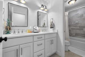 Full bathroom with double vanity and shower / tub combo