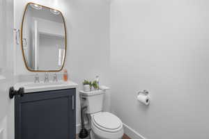 Half bathroom featuring vanity and toilet