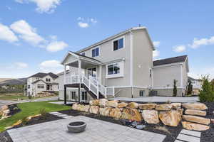 Back of house featuring a patio area, stairs, an outdoor fire pit, and a yard