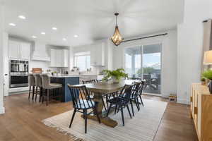 Dining room with recessed lighting and light wood-type flooring