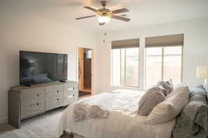 Bedroom featuring multiple windows, carpet floors, ceiling fan, and connected bathroom
