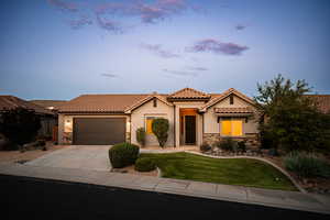 Mediterranean / spanish home featuring stone siding, a tiled roof, stucco siding, a garage, and driveway