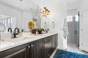 Full bath with double vanity, a stall shower, and tile patterned flooring