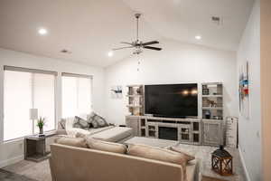 Living area with ceiling fan, lofted ceiling, recessed lighting, light carpet, and a fireplace
