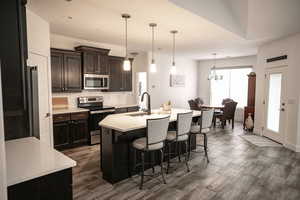Kitchen featuring appliances with stainless steel finishes, a kitchen breakfast bar, light countertops, decorative backsplash, and recessed lighting