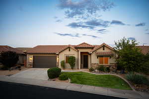 Mediterranean / spanish-style home with stone siding, stucco siding, concrete driveway, an attached garage, and a tile roof