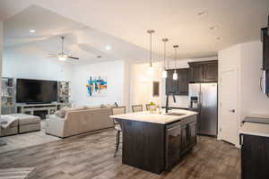 Kitchen with stainless steel appliances, dark brown cabinetry, dark wood-style floors, light countertops, and a ceiling fan