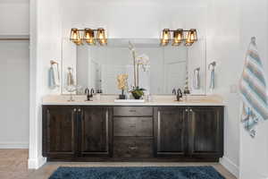 Bathroom featuring double vanity and baseboards