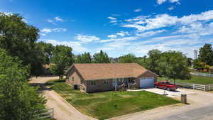 Single story home with driveway, brick siding, and a garage