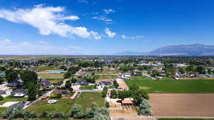 Aerial view of property and surrounding area featuring mountains and nearby suburban area