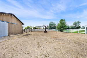 View of yard with an enclosed riding area and a view of countryside