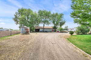 View of front of house featuring dirt driveway and an outdoor structure