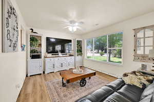 Living room with light wood-style flooring and a ceiling fan